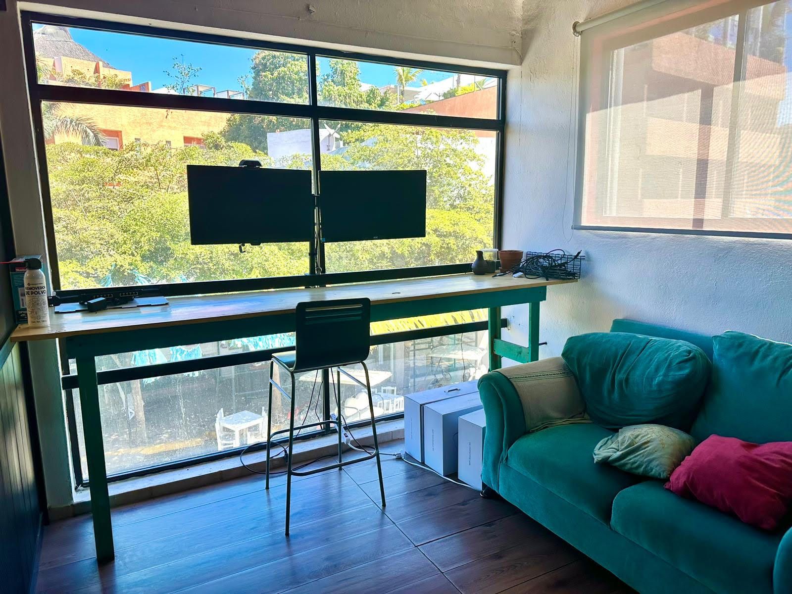 A private office room overlooking downtown Sayulita with an aquamarine couch and pink pillow
