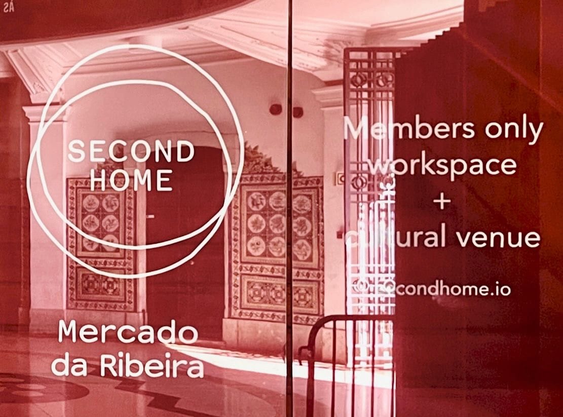 Second home red translucent entrance door with "members only workspace and culture venue" subtitle