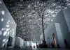 An amazing room bounces light off a modern buildings interior walls, as people walk around.